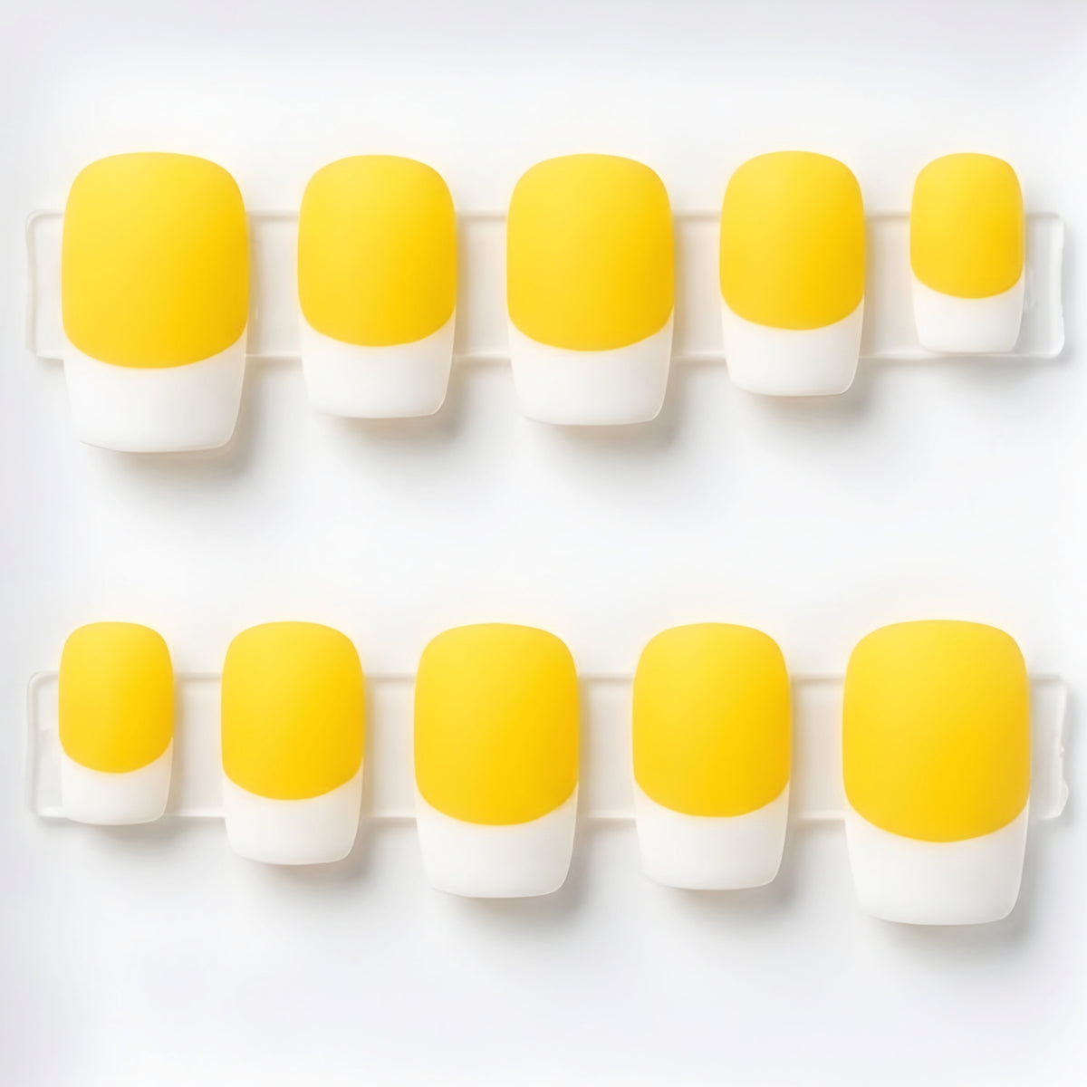 Ten false press-on nails arranged in two rows on a white background, featuring a yellow and white French tip design.