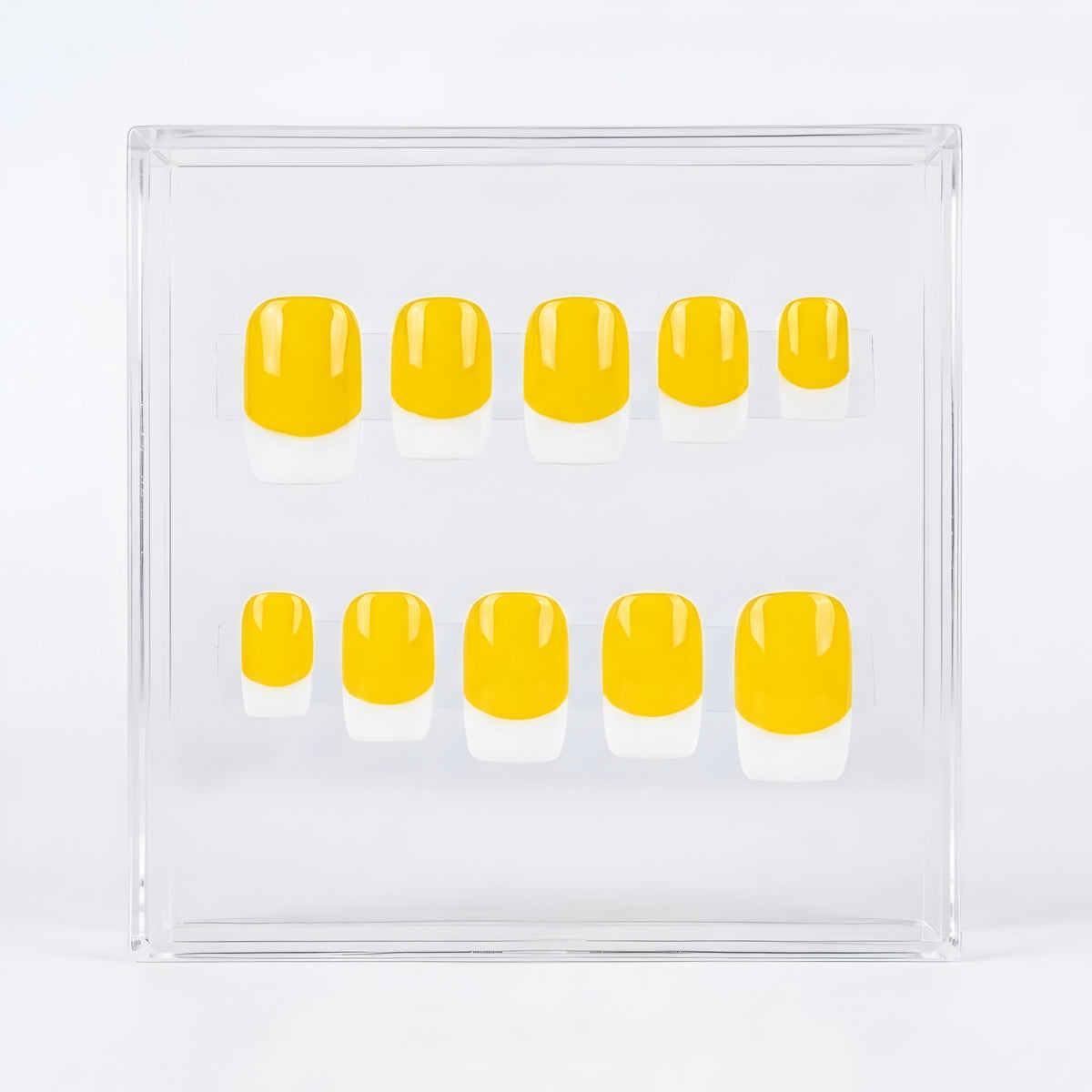 A set of ten press-on nails with a yellow and white French tip design, displayed inside a clear acrylic case on a white background.